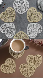 Close-up detail shot of Nordic PVC heart-shaped hollow gold-stamped coasters in scenic setup.