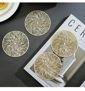 Round gold PVC coaster with hollow design, heat-resistant decorative cup mat for table decor.