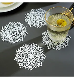 Gros plan détaillé sur les sous-verres en PVC blanc floral creux avec un design exquis.