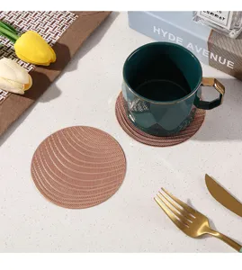 Close-up of textured round PVC coaster, heat-resistant table mat for coffee or drinks.