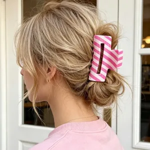 Pinza per capelli a righe rosa e bianche in PVC acconciata in uno chignon su capelli biondi