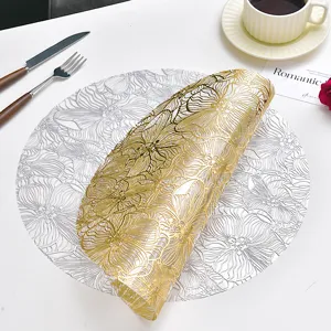 Dettaglio tovaglietta in PVC con motivo floreale traforato, elegante tappetino oro e argento.