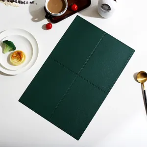 Detail shot of dark green leather placemat, rectangular table mat with grid design.