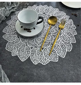 Primo piano dettagliato della tovaglietta in PVC bianco traforato con motivo a foglie eleganti.