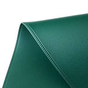 Dark green faux leather placemat detail, premium heat insulation table mat texture closeup.