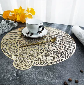 Detail view of the luxury gold hollow PVC placemat showcasing intricate geometric leaf patterns.