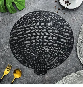 Detail view of a black hollow PVC placemat with intricate round geometric pattern for dining.