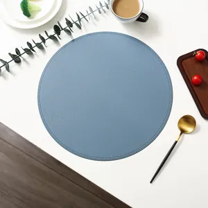 Round blue leather placemat detail view, premium waterproof and heat-resistant table mat.