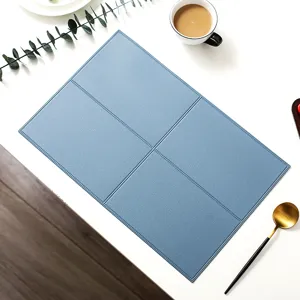 Detail shot of blue leather placemat showing exquisite grid stitching texture on table.