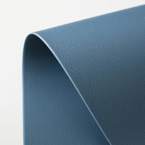 Close-up detail view of the luxury blue faux leather placemat showing fine texture and flexibility.