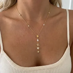 Detail view of gold stainless steel Y-necklace with sun, snake, and heart charms.