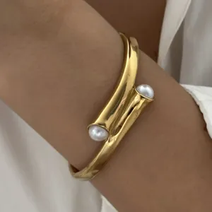 Elegante gedraaide goudkleurige roestvrijstalen armband met witte parels voor dames
