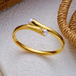 Gedetailleerde weergave van een vergulde roestvrijstalen armband met twee parels