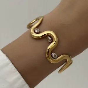 Schicker gewellter goldener Edelstahl-Armreif mit ovalen Kristallverzierungen