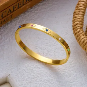 Detailopname van gouden roestvrijstalen armband met kleurrijke oogvormige edelsteengravures