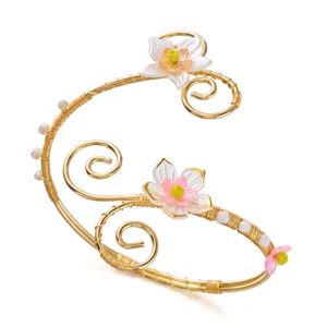 Dettaglio del bracciale da braccio floreale in filo dorato con eleganti petali rosa e perle