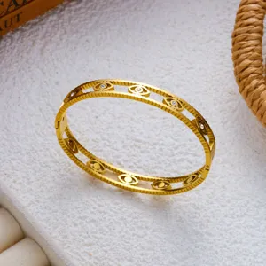 Detailansicht eines goldenen Edelstahl-Armreifs mit dem bösen Blick und Kristallen