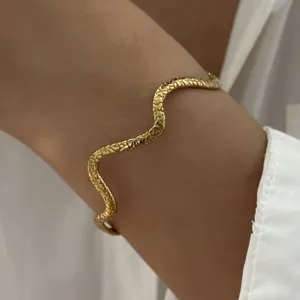 Macro close-up detail van de vintage slangentextuur op een goudkleurige golvende stalen armband