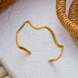 Detailweergave van vintage gouden roestvrijstalen armband met slangenprint patroon