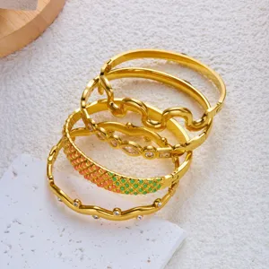 Detailansicht eines goldenen Edelstahl-Armreif-Sets mit Emaille-Karos und Kristallakzenten