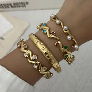 Gedetailleerde close-up van gestapelde gouden roestvrijstalen armbanden met edelstenen set