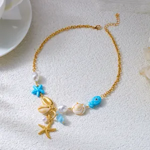 Vista macro dettagliata di una collana a tema marino con ciondoli a stella, conchiglia e pesce