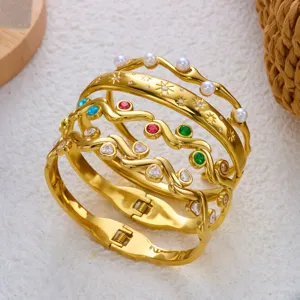 Gedetailleerde macro-opname van vergulde roestvrijstalen armbanden met gekleurde strass