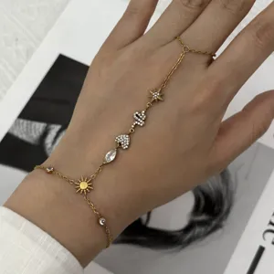 Gros plan d'un bracelet de doigt doré avec breloques en cristal cœur serpent et étoile