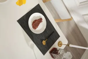 Close-up view of the dark grey woven PVC placemat in a modern dining table setting.