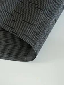 Close-up view of dark grey PVC woven placemat, highlighting fine texture and heat insulation.