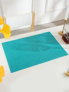 Teal PVC woven placemat in a luxury dining table scene, heat-resistant and waterproof decor.