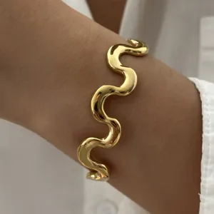 Detailansicht eines minimalistischen gewellten Goldarmbands aus Edelstahl am Handgelenk