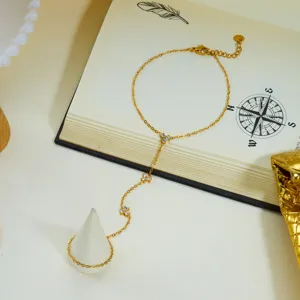 Gros plan d'un bracelet de doigt en acier dore avec des breloques en zircon sur un livre