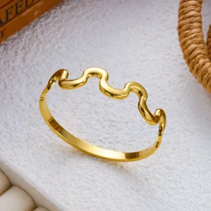 Detailansicht eines polierten goldfarbenen Edelstahlarmbands mit schickem Wellendesign.