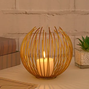 Detail view of modern gold metal wire candle holder with glowing candle for home decor.