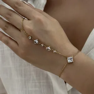 Élégant bracelet de main en acier inoxydable doré avec des pierres en zircone cubique carrées.