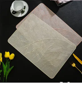 Detailed view of rectangular PVC placemat featuring golden feather texture, ideal for table decor.