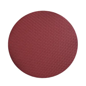 Detailed view of round wine red woven leather placemat, waterproof heat insulation table mat.