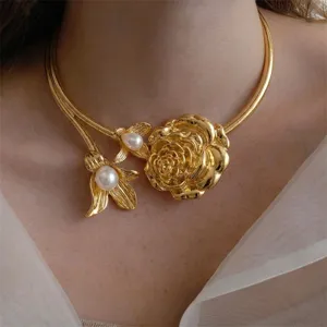 Close-up of vintage gold rose choker necklace with white pearls and floral design
