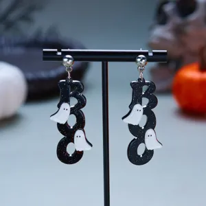 Detail showing BOO ghost earrings for Halloween on a minimalist black display stand