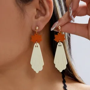 Macro view showing the detailed ghost pendant and orange maple leaf on Halloween earrings