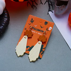 Macro view of Halloween ghost earrings with maple leaf detail on orange card