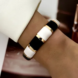 Detailed macro shot of a vintage black and white enamel bangle with gold-tone accents