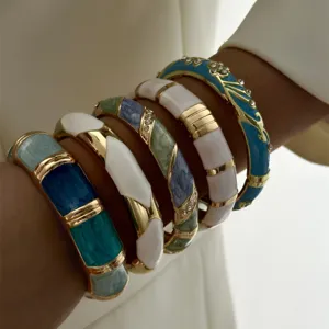 Detaillierte Makroansicht von bunten Vintage-Emaille-Armreifen mit Goldakzenten