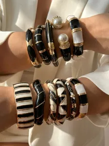 Elegant close-up of vintage black and white enamel bangles stacked with pearl accents