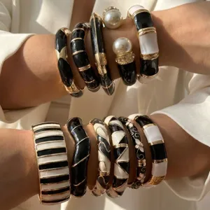 Detailed view of retro black and white enamel bangles set with gold-tone metal accents