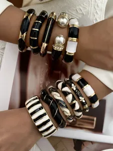 Detailed view of vintage black and white enamel bangles with gold accents and pearls