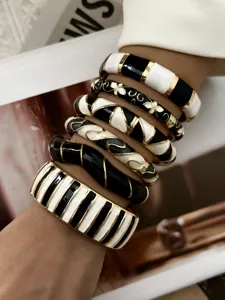 Close-up detail of stylish vintage black and white enamel stackable bracelets on a wrist