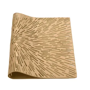 Primo piano dettagliato della tovaglietta in PVC dorato traforato con motivi geometrici.
