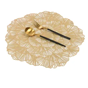 Detail view of gold hollow PVC placemat featuring a stylish ginkgo leaf pattern for home decor.